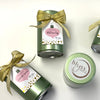 Green tins with gold bows and 'blyss' labels on a white background